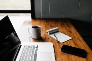 Coffee, notepad and laptop on a desk