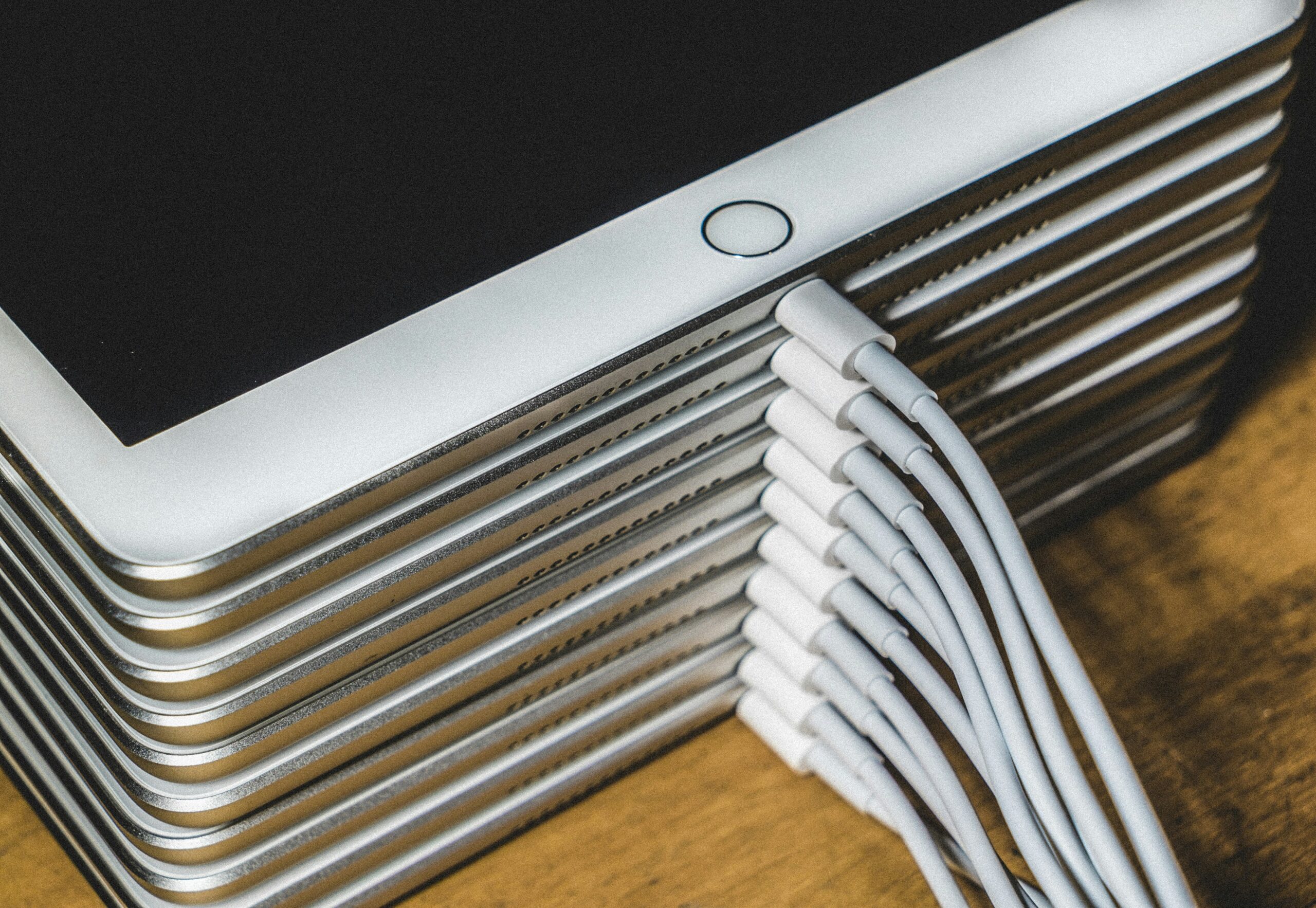 A stack of ipads with recharging plugs