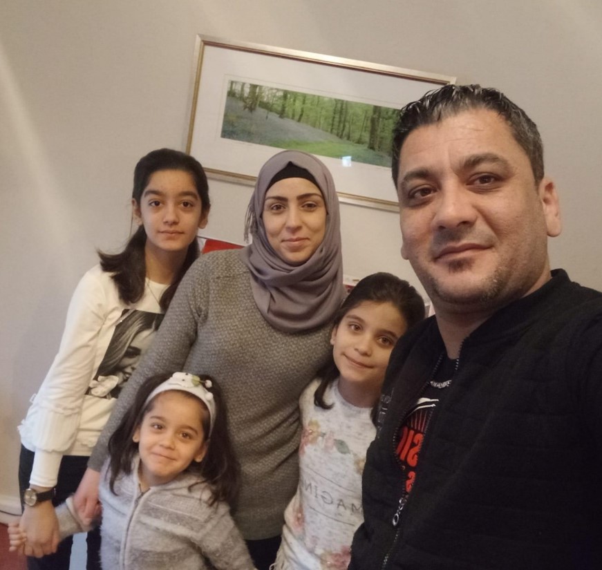 Photo of Mohammad, Roba and their three daughters, all smiling