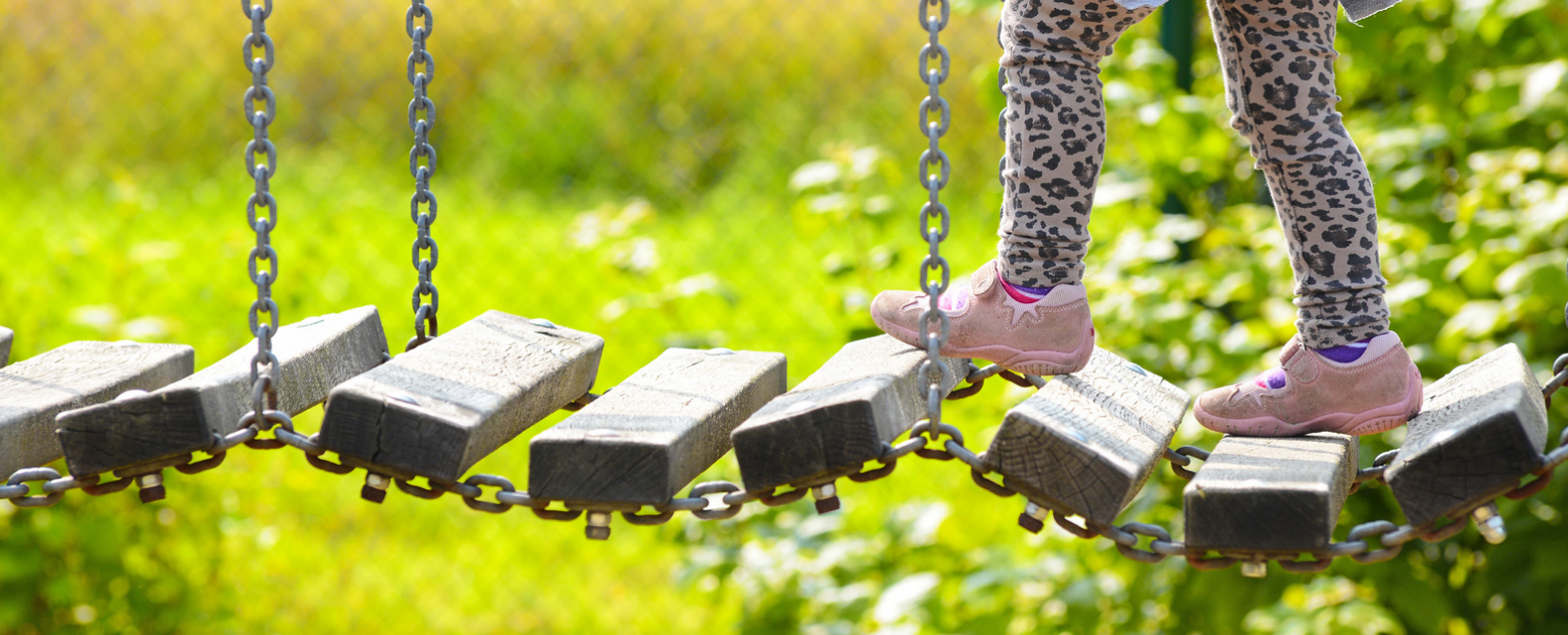 Photo of a child's legs on a playground bridge